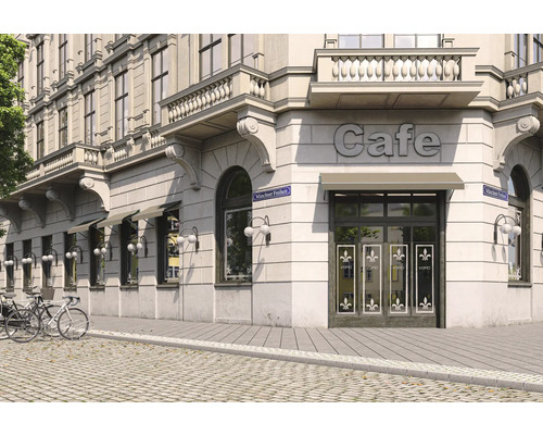 Außenansicht eines Cafés in einem Gebäude mit architektonischen Details und Fahrrädern im Vordergrund.