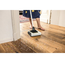 Akku-Besen im Einsatz auf einem Holzboden mit Konfetti