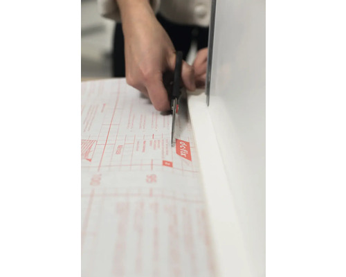 Zuschneiden einer Folie mit einer Schere.