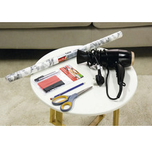 Dekorfolie, Rakel, Cutter, Fön, Bleistift und Schere auf einem Tisch