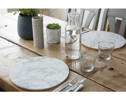 Dekorierter Esstisch mit Tischsets, Karaffe und Gläsern