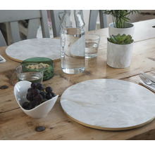 Tischdekoration mit Tellern, Gläsern, Wasserkaraffe, Schale mit Weintrauben und Pflanzen auf einem Holztisch