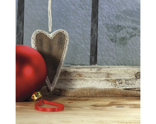 Dekorative Holzherz Anhänger mit roter Weihnachtskugel vor gefrorenem Fenster