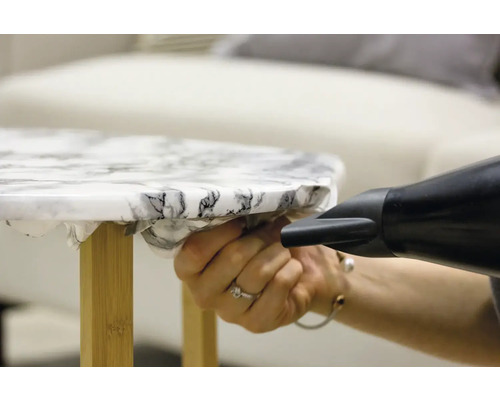 Dekorfolie wird mit einem Fön auf einen Tisch aufgebracht