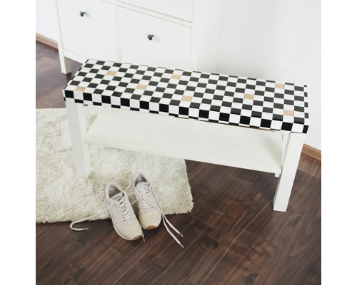 Weiße Schuhbank mit Schachbrettmuster und Ablage, darunter ein Paar Schuhe.