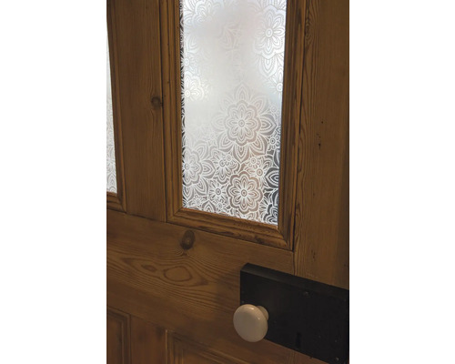 Holztür mit floral gemustertem Glas und einem Türknauf