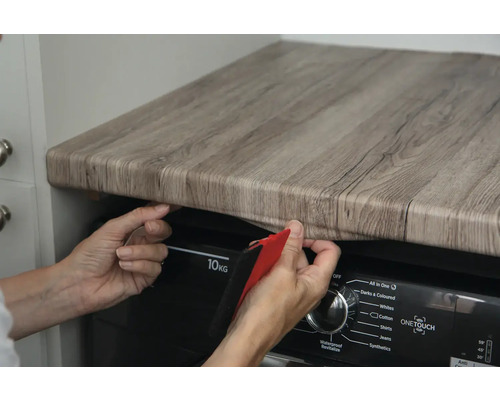 Dekorfolie in Holzoptik wird auf einem Tisch angebracht