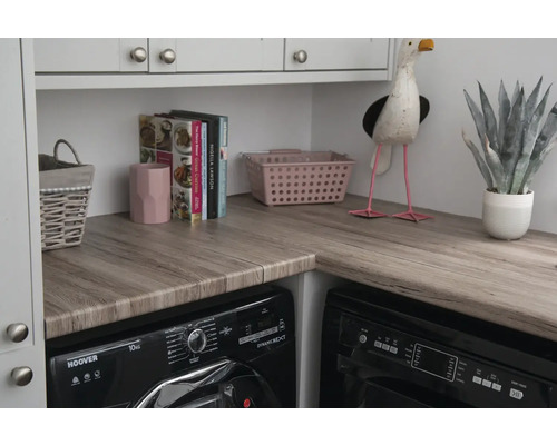 Waschküchenszene mit Waschmaschine, Trockner und dekorativen Elementen auf einer Arbeitsplatte