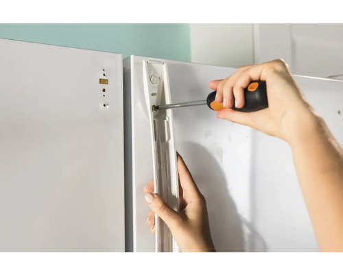 Montage einer Schranktür mit einem Schraubendreher