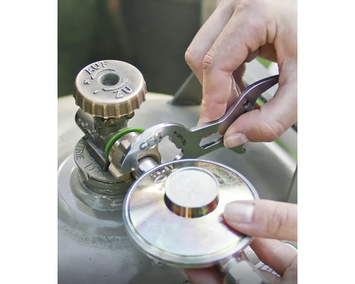 Eine Person benutzt einen Ventilschlüssel an einer Gasflasche.