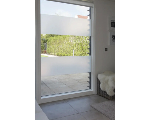 Blick durch ein Fenster mit Sichtschutzfolie auf eine Terrasse und einen Garten