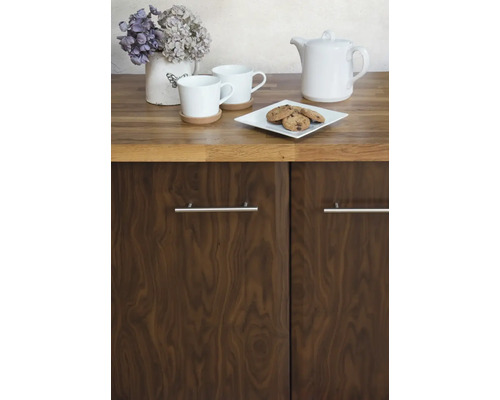 Küchenszene mit Geschirr, Gebäck und hölzernen Küchenschränken.