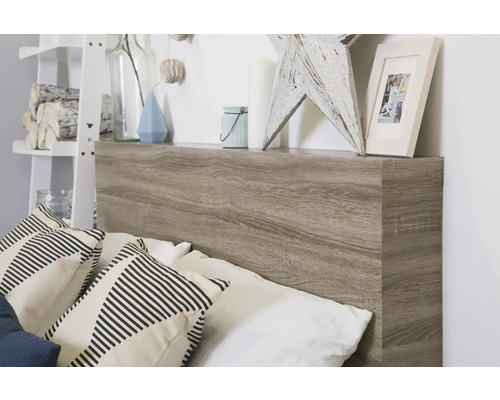 Bett mit Kopfteil aus Holz und Ablagefläche mit Dekoration