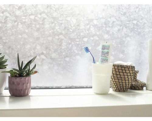Badezimmerfenster mit Milchglasfolie, Zahnputzbecher, Korb und Zimmerpflanzen auf einem Fensterbrett
