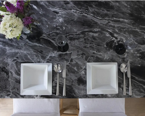 Gedeckter Esstisch mit Marmorplatte, Tellern, Besteck, Gläsern und Blumenvase