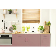 Helle Küche mit rosa Schränken, Holzjalousien und verschiedenen Küchenutensilien.