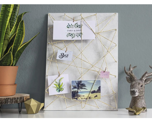 Dekoratives Memoboard mit Schnur und Fotos auf einem Tisch