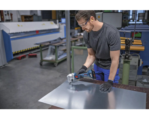 Handwerker schneidet Metallblech mit Akku-Blechknabber