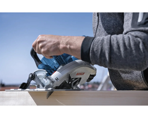 Handkreissäge beim Schneiden von Holzbrett. Bosch Logo.