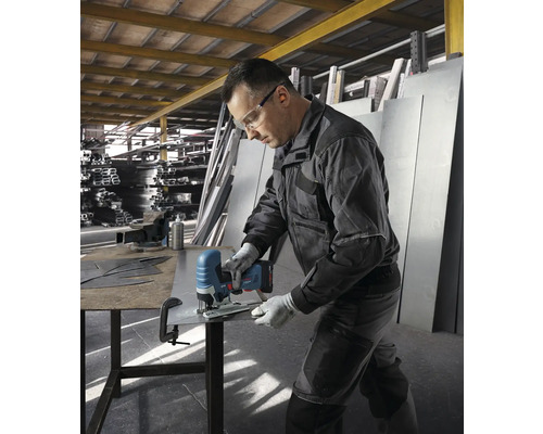 Ein Mann schneidet mit einer Akku-Stichsäge ein Metallblech