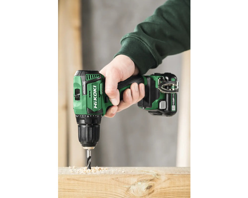 Eine Person bohrt mit einem Akku-Bohrschrauber ein Loch in ein Holzbrett.