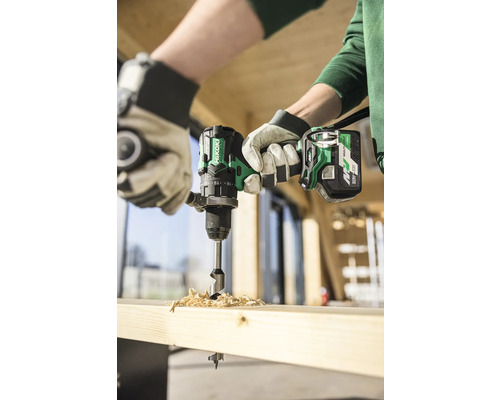 Handwerker bohrt mit einem Akkubohrer ein Loch in ein Holzbrett.