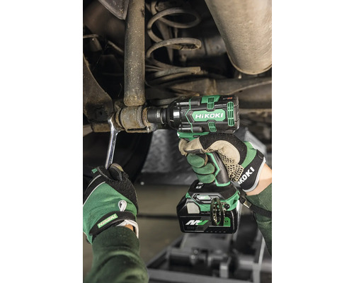 Eine Person benutzt einen Akku-Schlagschrauber von HiKoki, um an einem Auto zu arbeiten.