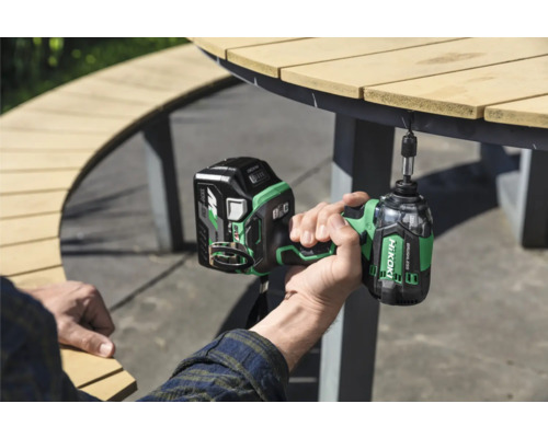 Eine Person verwendet einen Akku-Schlagschrauber von HiKoki an einem Gartentisch.