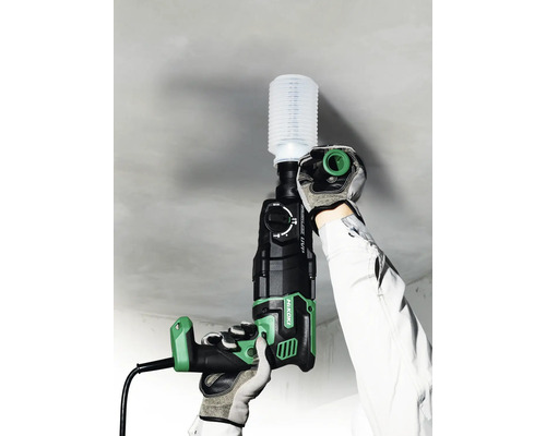 Ein Bediener bohrt mit einem Bohrhammer der Marke Hikoki in eine Decke, wobei ein Staubabsauger verwendet wird.