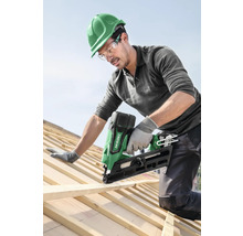 Handwerker befestigt Holzlatte mit einem Akku Nagelgerät auf einem Dach