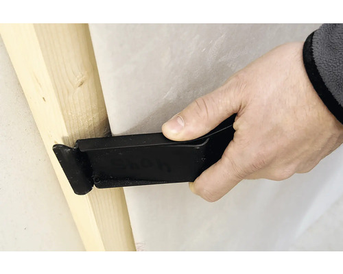 Ein Werkzeug wird verwendet, um eine Folie an einem Holzrahmen zu befestigen.