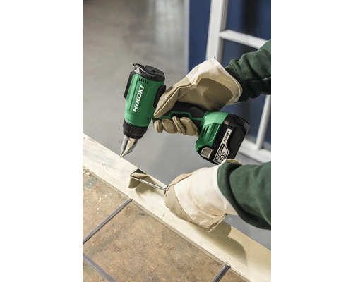 Akku Heißluftpistole im Einsatz beim Entfernen von Farbe mit einem Schaber