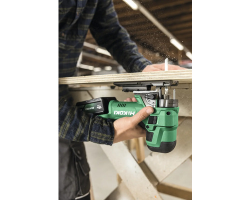 Eine Person verwendet eine Akku-Stichsäge von Hikoki, um ein Holzbrett zu sägen.