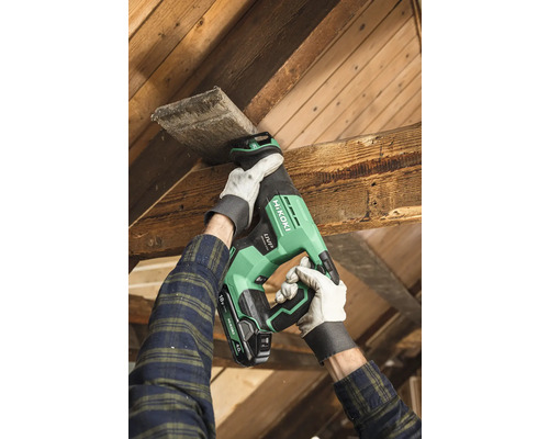 Eine Person sägt mit einer Akku-Säbelsäge ein Holzbrett.