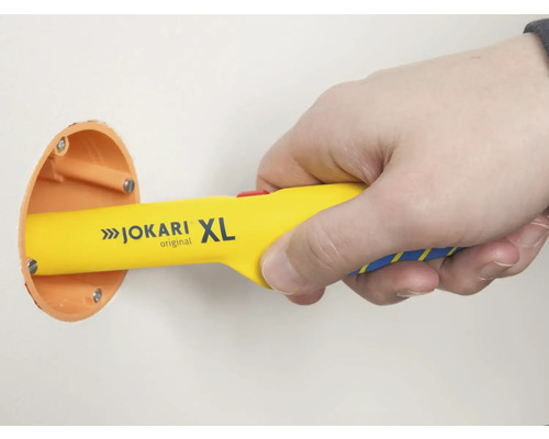 Hand mit Jokari XL Kabelentmanteler an einer Verteilerdose in der Wand