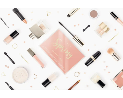 Kosmetikprodukte wie Lippenstift, Mascara, Nagellack und Lidschatten auf hellem Hintergrund