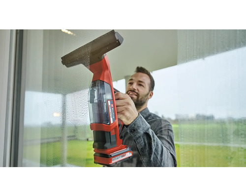 Mann reinigt Fenster mit einem Akku-Fenstersauger