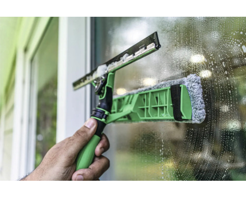 Fensterputzer mit Teleskopstiel bei der Arbeit