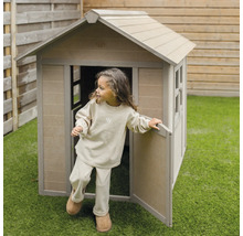 Kind verlässt ein Spielhaus aus Holz im Garten.