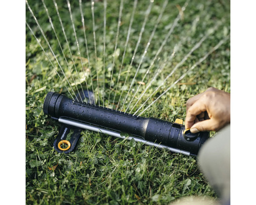 Wassersprenger mit Bedienung auf Rasen