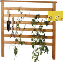 Holzspalier mit Pflanzen, Gartengeräten und Dekoration
