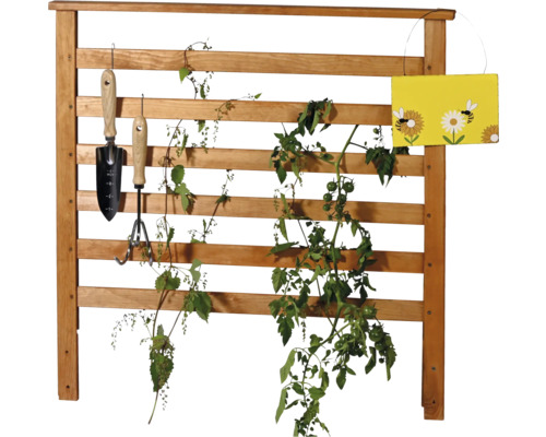 Holzspalier mit Pflanzen, Gartengeräten und Dekoration
