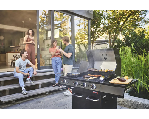 Szene mit einem Gasgrill und einer Gruppe von Menschen im Freien, die sich unterhalten