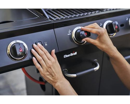 Nahaufnahme eines Char-Broil Gasgrills mit Händen, die Zündknopf und Drehknopf bedienen.