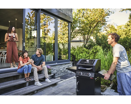 Personen grillen im Freien mit einem Gasgrill von Char-Broil auf einer Terrasse.