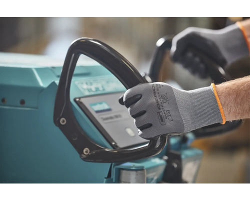 Eine Person bedient eine Reinigungsmaschine mit Schutzhandschuhen.