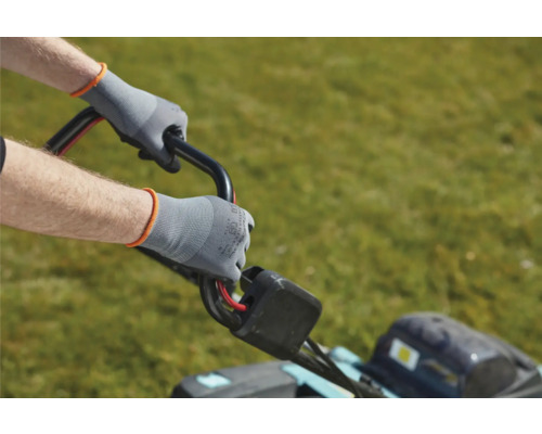 Person bedient Rasenmäher mit Arbeitshandschuhen.