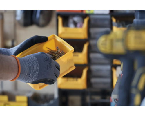 Person hält eine gelbe Kunststoffbox mit Schrauben in der Hand vor einem Regal mit Lagerboxen.