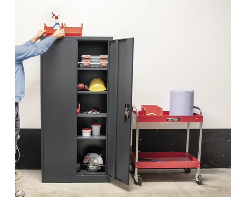 Werkzeugschrank mit geöffneter Tür und Werkzeugwagen im Werkstattbereich