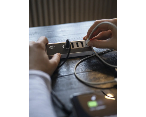 Person schliesst USB-Kabel an USB-Hub an.